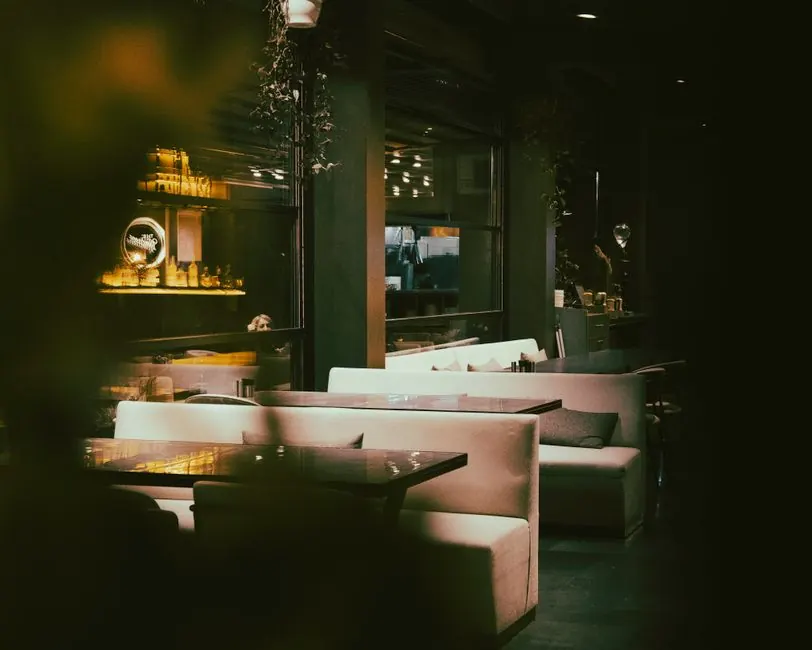 Cozy seating in a dimly lit, elegant restaurant interior, with modern decor and ambient lighting.